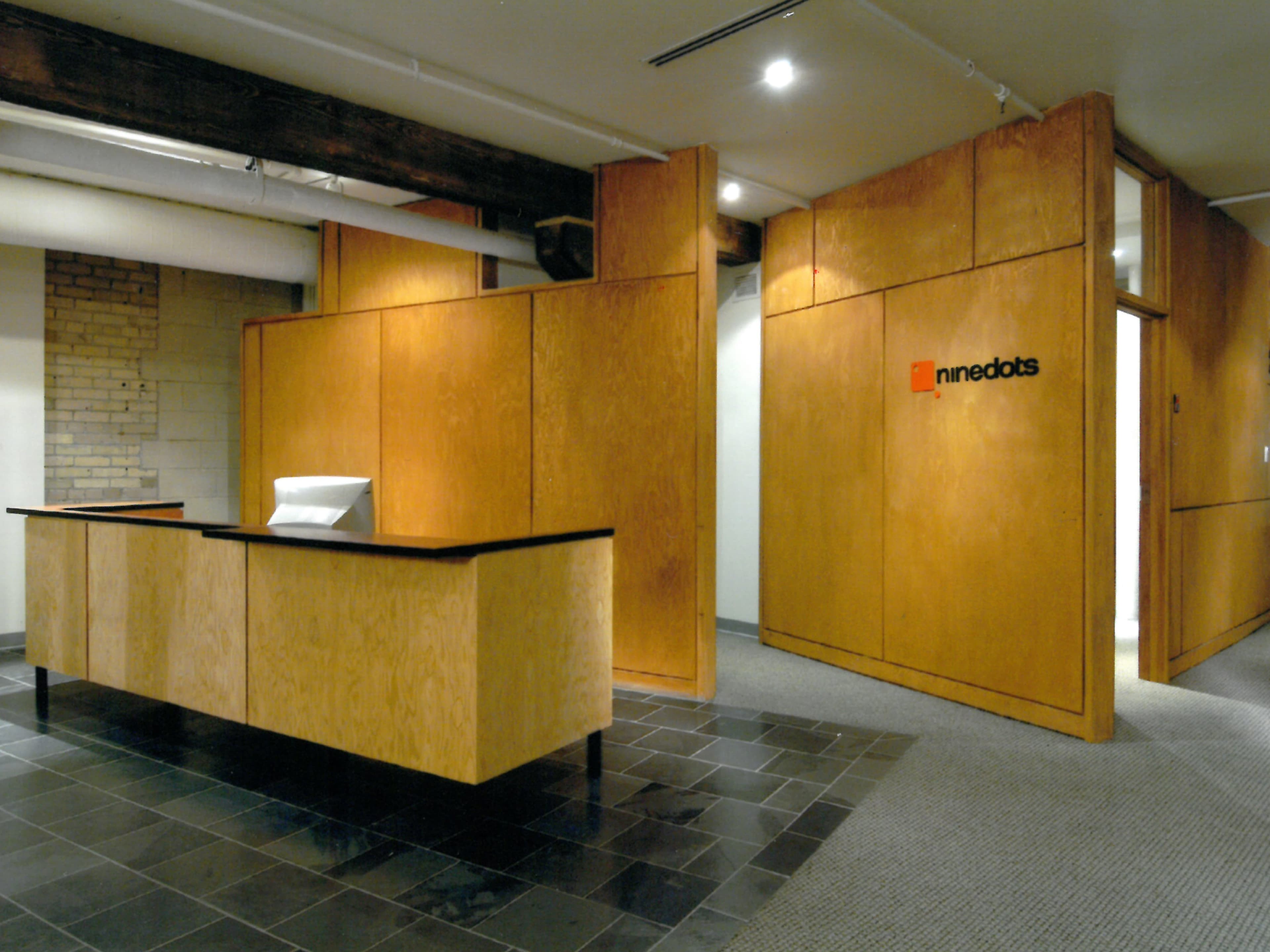 Set within a converted warehouse, the Nine Dots office balances industrial character with refined craftsmanship. Birch plywood panels, glazed partitions, and exposed brick create a warm, open workspace that reflects the client’s creative and technology-driven identity.