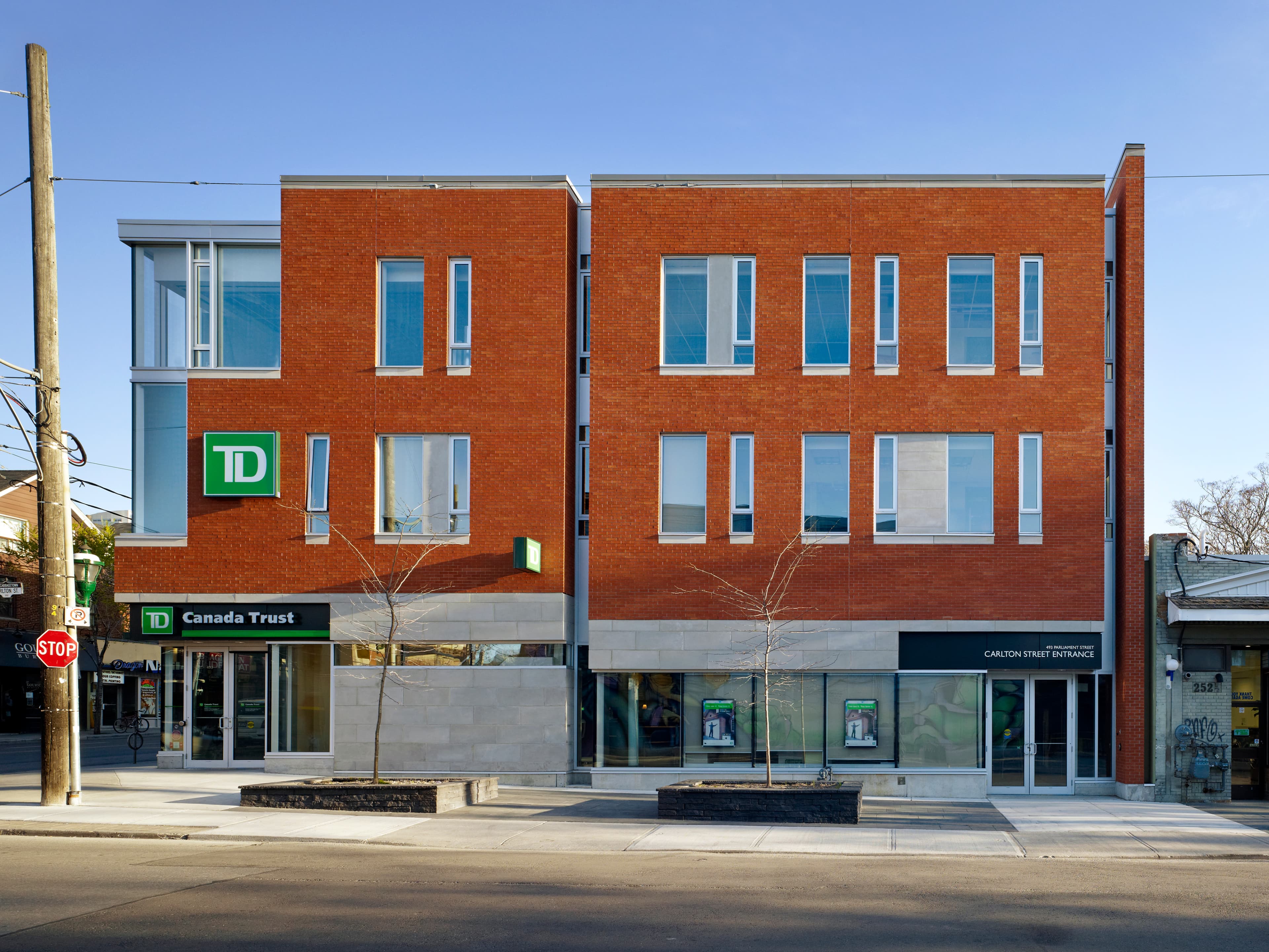 This three-storey commercial building was designed for a prominent corner in Cabbagetown, using red brick, stone, and glass to create a contemporary yet durable expression. The ground floor and much of the second are occupied by a bank branch, while the remaining space is organized as flexible offices. Clear massing and resilient materials give the project a strong civic presence and long-term adaptability.